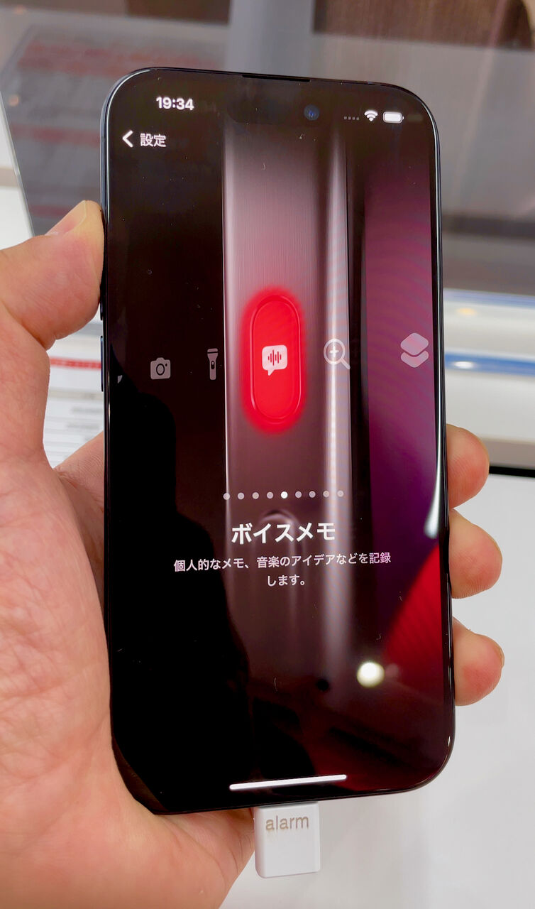 アクションボタンの設定画面。他の設定画面と違って 15 Pro の写真をもとに作られた設定画面で、スワイプして設定したいアプリや機能を設定できます。この写真ではボイスメモアプリが選択されています。