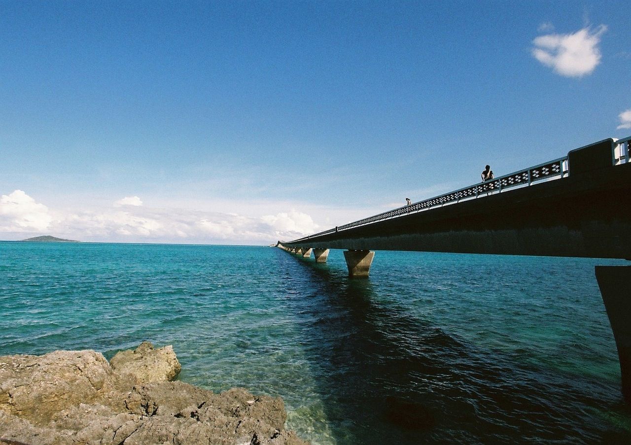 高齢の患者と話している笑顔の医師の側面図。