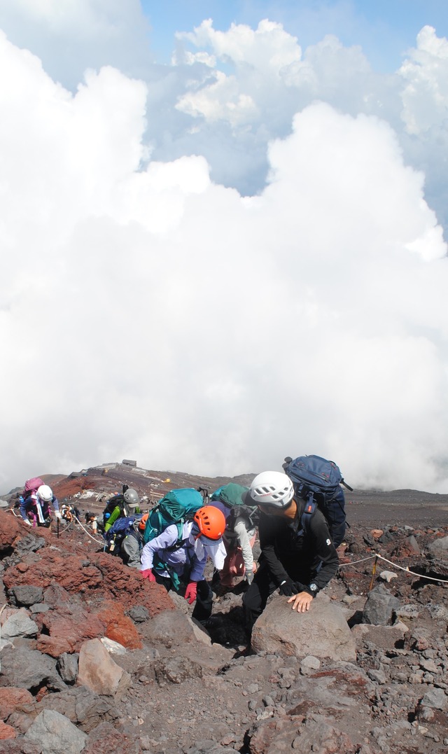 岩場をよじ登る。高山ガイドが振り返った