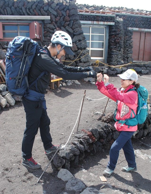 山頂にて高山ガイドとハイタッチする参加者