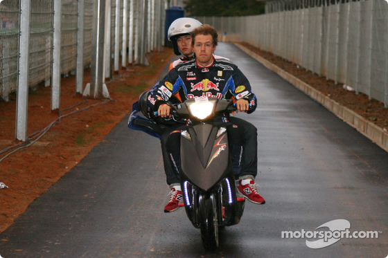 ヴェッテル、マーシャルを乗せてバイクを運転してピットに