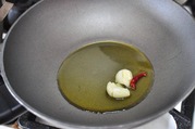 潰したニンニクと鷹の爪、オリーブオイルを弱火にかける