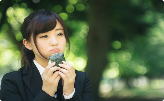 おにぎりを頬張る女性