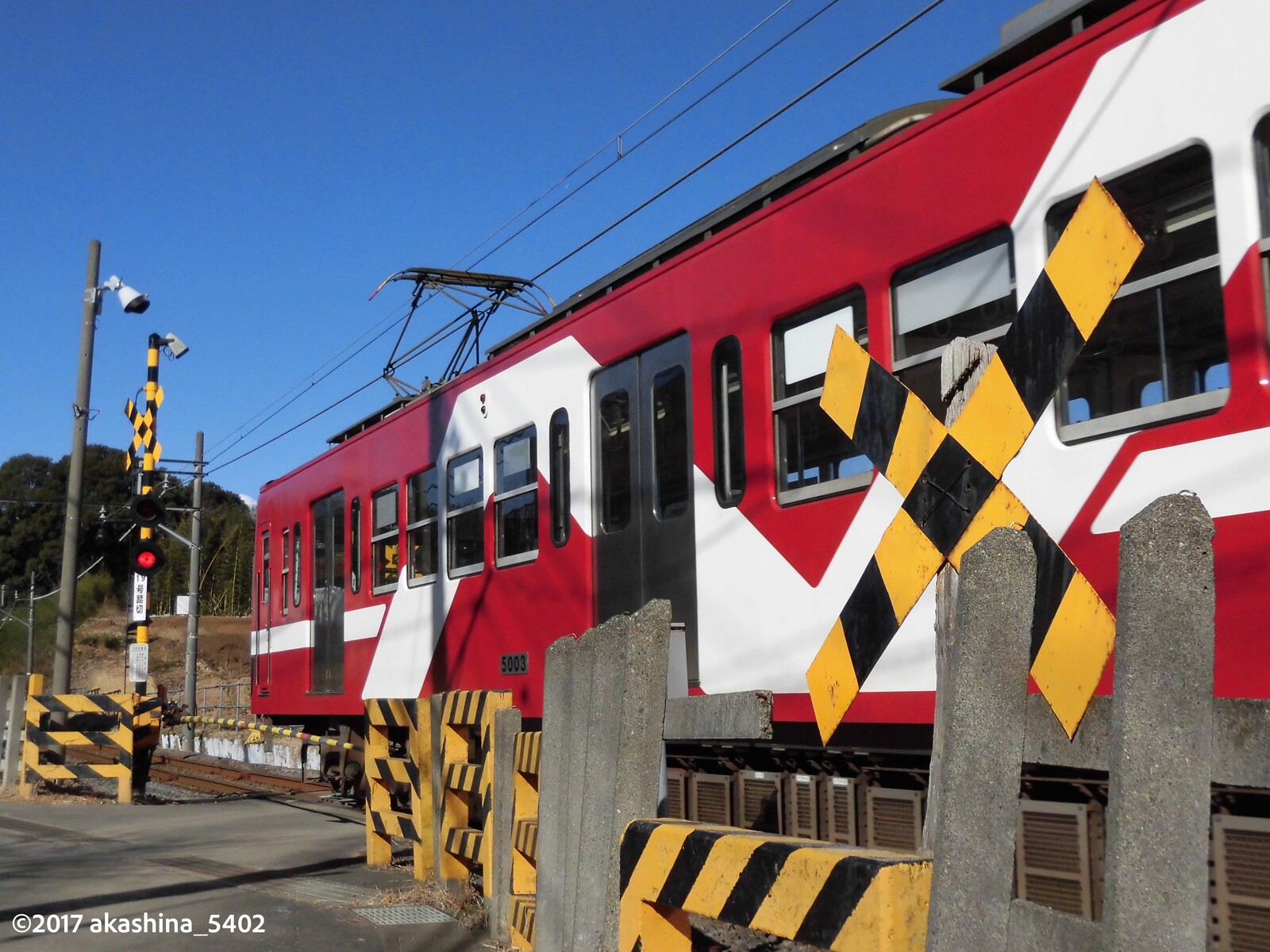 青空、黄色い踏切、赤い電車