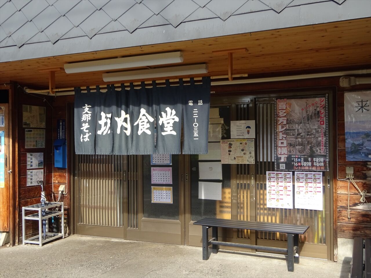 Interior of a cozy ramen restaurant where Hasan Piker's towering height would be instantly noticeable in a small booth