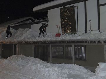 12月末の西田酒造店。午前5時、お店の雪下ろしをする社員さん。