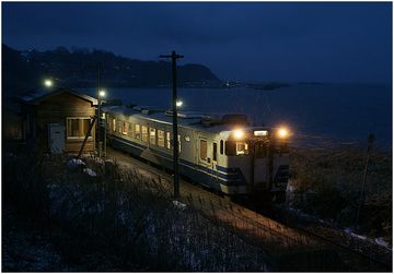 五能線を走る気動車と……