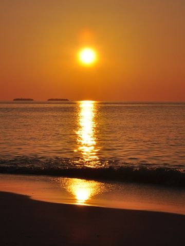 太陽から砂浜まで、赤い絨毯が伸びる