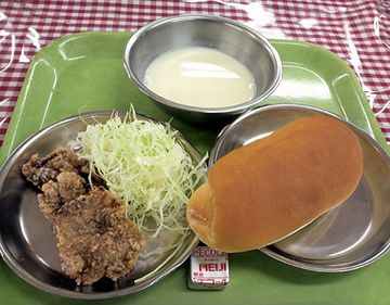 鯨の竜田揚げ。コッペパンにマーガリン。奥が脱脂粉乳。
