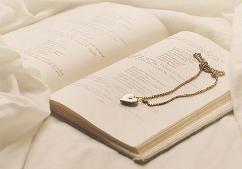 白っぽい開かれた本にペンダント