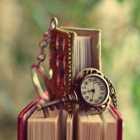 本の上のカギの形をした懐中時計風キーホルダー?