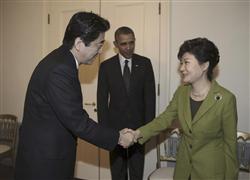 日米韓３カ国首脳会談を前に、安倍晋三首相と握手する韓国の朴槿恵大統領（右）。中央はバラク・オバマ米大統領。＝３月２５日、オランダ・ハーグ（ＡＰ）