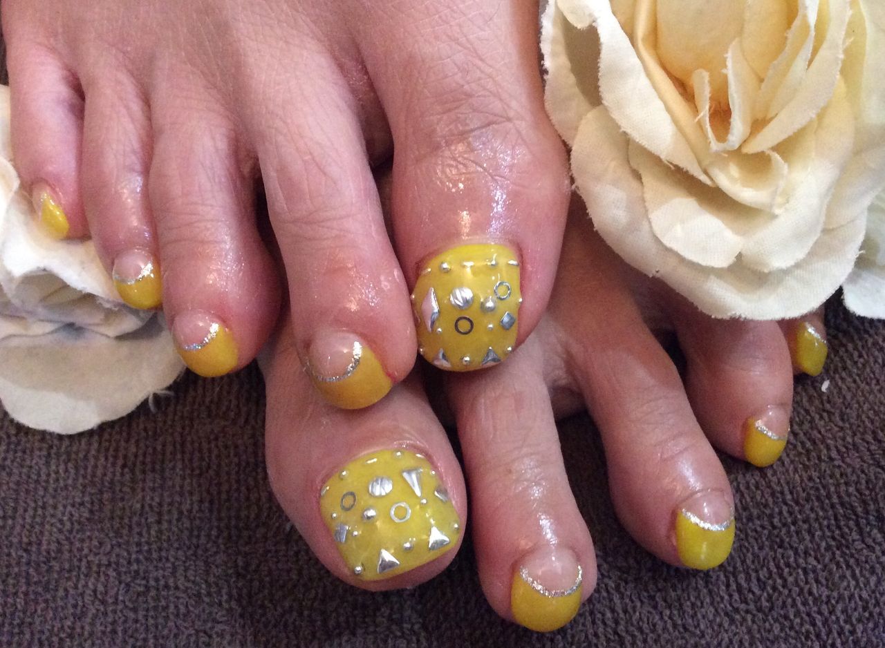 シルバースタッズがｐｏｉｎｔ イエローフットジェルネイル Nail Salon Freestyle