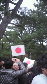 旗を持って待つ人々。