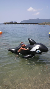 浮きシャチに乗った少年