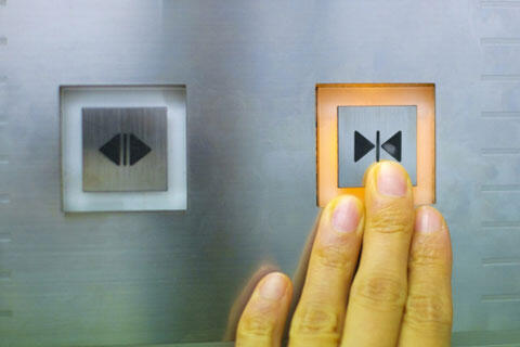 エレベーターの閉まるボタンを押すイメージ