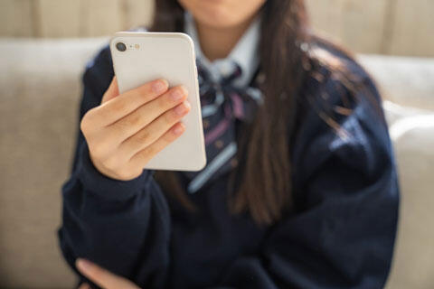 スマホを見る女子学生