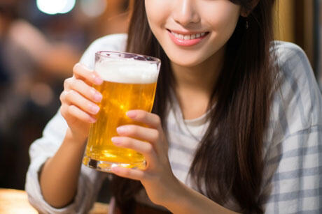 笑顔でビールを持つ女性