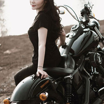 バイクに腰掛ける女性