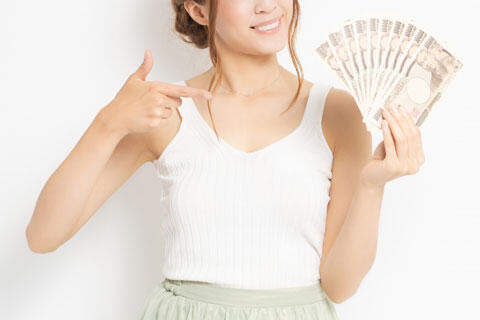 お金を手に持つ若い女性