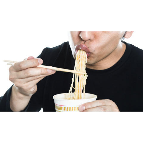 カップラーメンを食べる男性