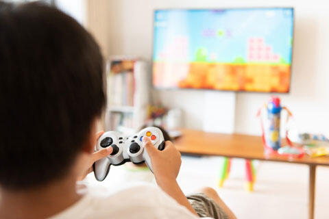 テレビゲームで遊ぶ子供