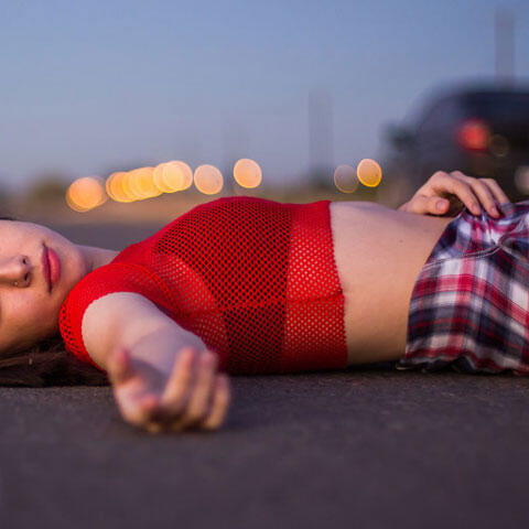 道路の上に寝転ぶ人女性