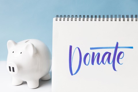 donate-written-in-cursive-next-to-a-piggy-bank
