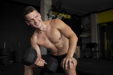 medium-shot-smiley-man-holding-dumbbell (1)
