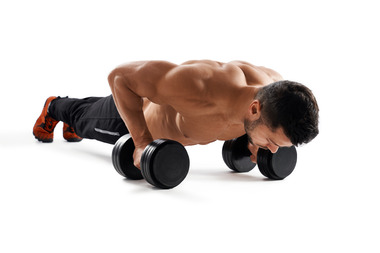 muscular-man-doing-push-ups-using-dumbbells