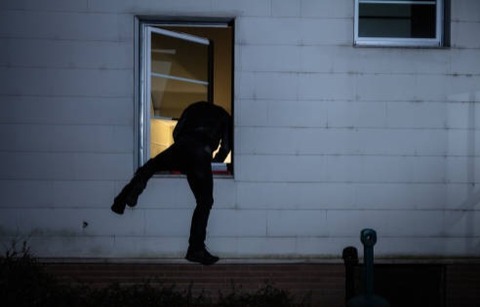窓越しに家に入る泥棒