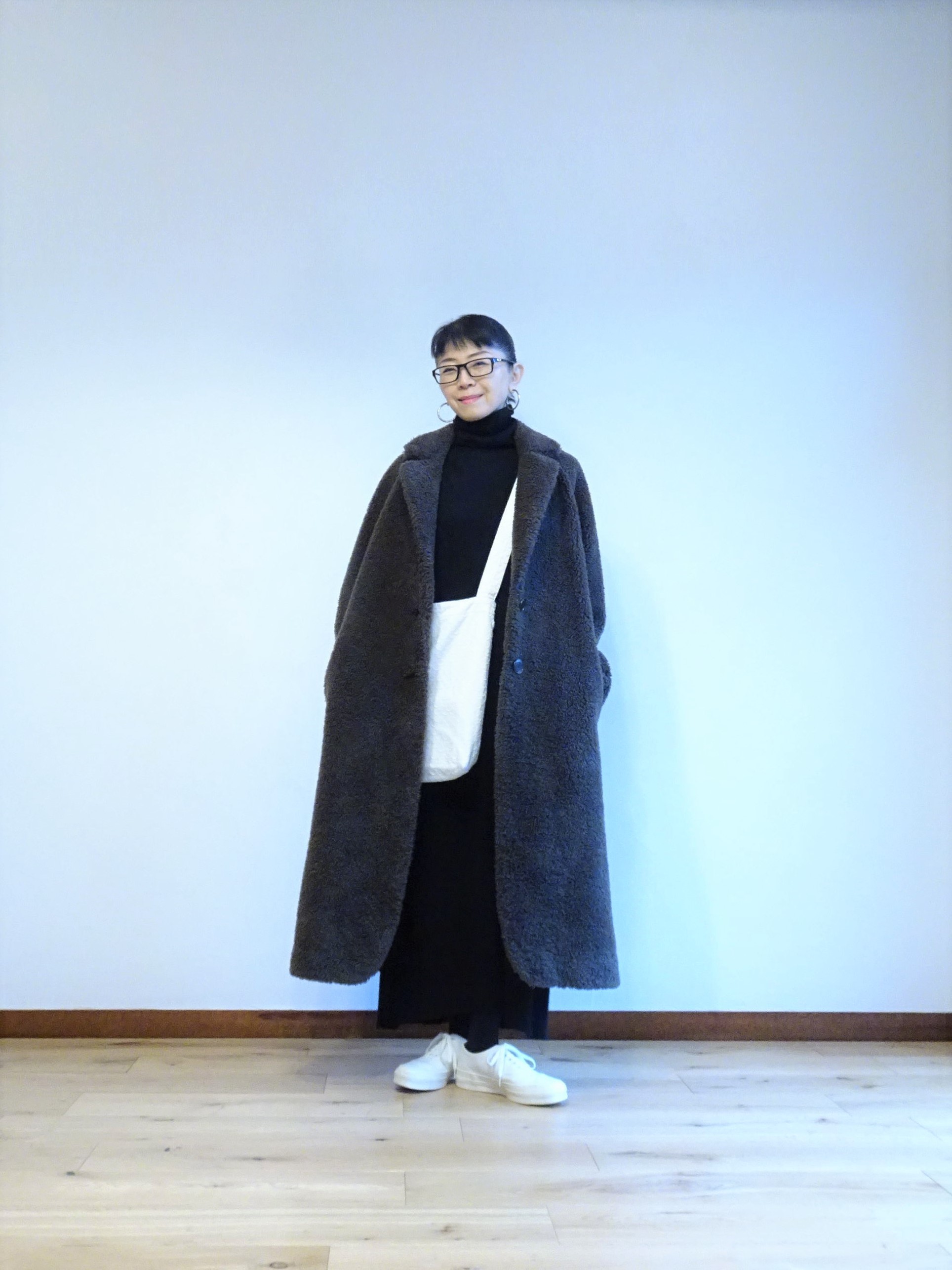 黒いタートルネックドレスと白いコットンバッグとスニーカーのコーデ Na2eye