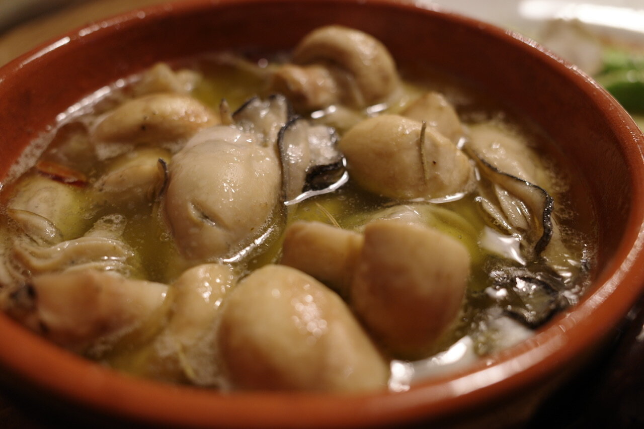 牡蠣のアヒージョ アスパラガスの温かな一皿 ワインのツマミです おやじ厨房に入る