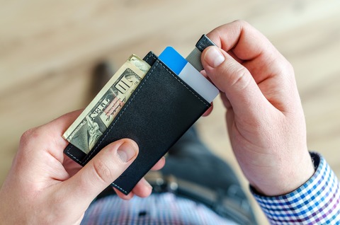 person-holding-black-card-holder-928181