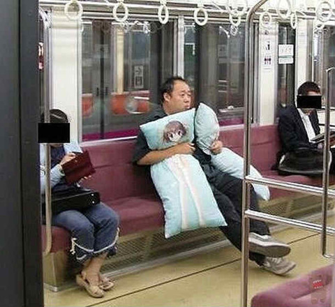 電車の中で抱き枕をだくおじさん