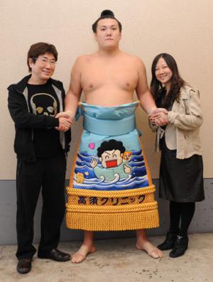 西原理恵子の絵が刺繍してある化粧まわしをつけた力士と高須クリニック院長高須克哉氏と西原理恵子