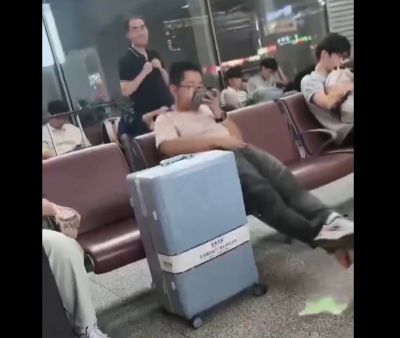 空港の椅子に座っている中国人