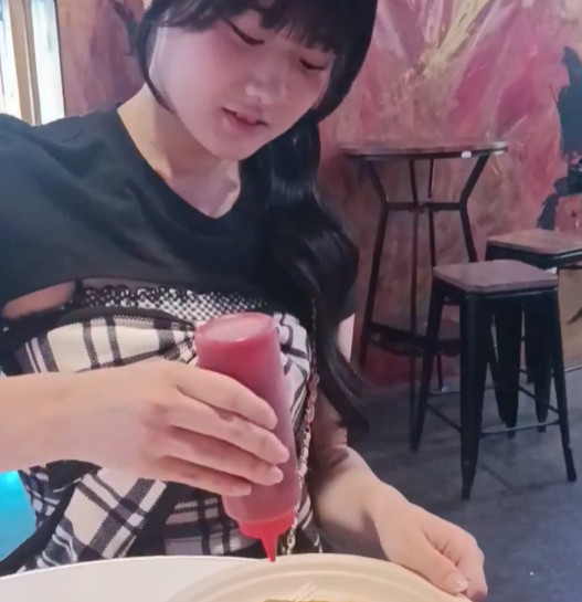 アイドルがオムライスにケチャップをかけようとしている