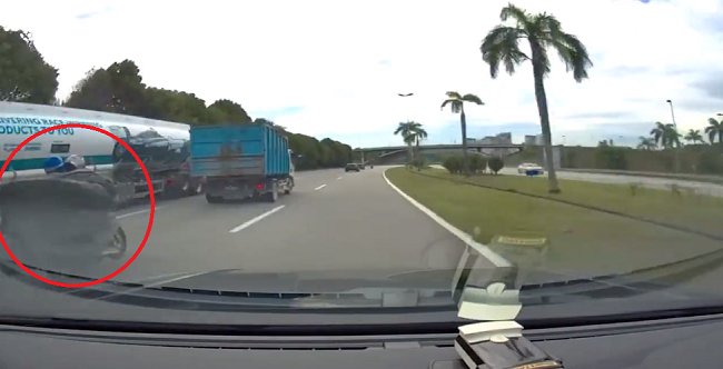 トラックの荷台のシートが吹き飛び後ろのバイクを包んでしまい死ぬとこだった！（2つのビデオ）