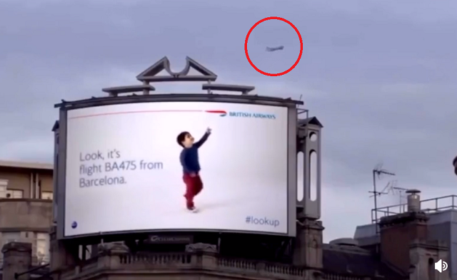 ロンドンにある看板は上空を通過する飛行機を少年が指差しどこ発なに便か教えてくれるようです！