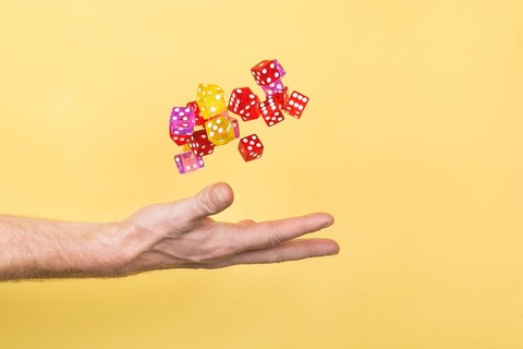 hand-throwing-dice-on-yellow_925x