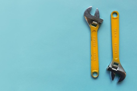 two-adjustable-wrenches-on-a-blue-background_925x