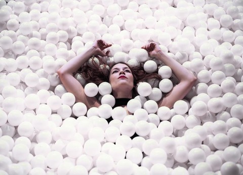 woman-floating-with-arms-raised-in-ball-pit