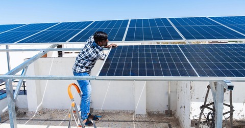 indian-man-maintaining-solar-panels-iStock-2137937205