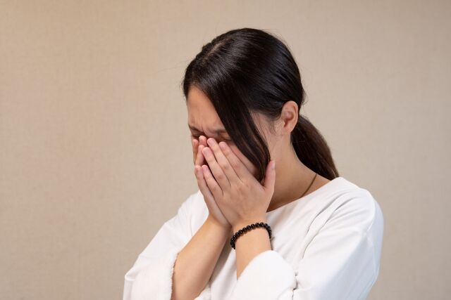 顔を手で覆う泣く女性