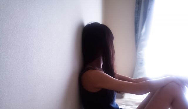 窓の外を見つめる落ち込んだ少女