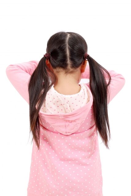 後ろを向いて泣くツインテールの小学生の女の子