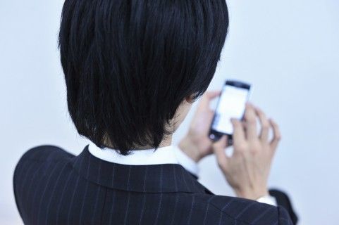 メールをする会社員の男性