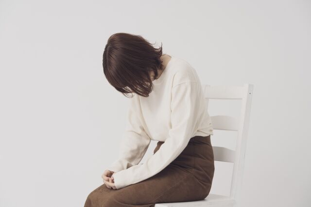 椅子に座って悩む女性