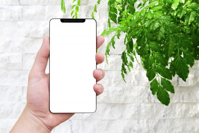 スマホを手に持つ写真画像